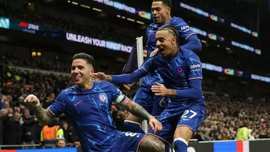 Premier League: Chelsea rallied from a two-goal deficit to defeat Tottenham 4-3 on Sunday, moving to within four points of league leaders Liverpool after Arsenal drew with Fulham. Chelsea's Enzo Fernandez celebrates with teammates after scoring the team's third goal. (AP Photo/Ian Walton)(AP) Chelsea's Enzo Fernandez celebrates with teammates after scoring the team's third goal. (AP Photo/Ian Walton)(AP) Both Arsenal and Chelsea began the day seven points behind Arne Slot's side, whose match this weekend was postponed due to stormy weather. Arsenal had to settle for a 1-1 draw, but Enzo Maresca's Chelsea, who played later on Sunday, staged a remarkable comeback at the Tottenham Hotspur Stadium. Dominic Solanke and Dejan Kulusevski gave Spurs a two-goal lead within the first 11 minutes, but Jadon Sancho quickly pulled one back with a fine strike. The second half was dominated by the visitors. Cole Palmer equalized with a penalty in the 61st minute, and Enzo Fernandez put Chelsea ahead 12 minutes later. Palmer's composed "Panenka" penalty provided the visitors with a two-goal cushion before Son Heung-min scored a late third for Spurs. Chelsea, now in second place, have 31 points from 15 games, two points ahead of London rivals Arsenal. Liverpool, with a game in hand, lead with 35 points. "The plan or the idea is to not let the players slow down," Maresca told Sky Sports. "They cannot drop because they know another player is waiting to come in." Despite the impressive victory, Maresca, in his first season at Stamford Bridge, downplayed his team's title prospects. "Arsenal, (Manchester) City and Liverpool probably don't slide like (Chelsea defender Marc) Cucurella did. To be serious, we are not ready, we are far from these teams but we focus on day-by-day and trying to improve the team." The defeat is a major setback for Spurs manager Ange Postecoglou, whose team recently thrashed champions Manchester City 4-0. "It is a sore one, a painful one," said the Australian, whose side now sits 11th in the Premier League table after their seventh defeat. Earlier, Arsenal had a late winner disallowed for offside by a VAR review, ending their four-match winning streak in west London. Raul Jimenez gave Fulham an early lead before William Saliba equalized with yet another Arsenal goal from a corner. "We are very disappointed not to win the game -- overall we absolutely dominated the game from start to end," Arsenal manager Mikel Arteta told the BBC. "We did all the things that we wanted to do during the game and unfortunately we concede one goal in one shot. The way the team played, the way the team wanted to win, it was unbelievable." Arsenal were missing key defensive players Gabriel Magalhaes and Riccardo Calafiori due to injury, and Fulham exploited a makeshift left side of Arsenal's defense to take the lead. Kenny Tete's pass found Jimenez, who surged forward and scored brilliantly across David Raya into the far corner on 11 minutes. Arsenal showcased their set-piece prowess by scoring twice from corners to beat Manchester United 2-0 in midweek. Despite their preparations, Fulham couldn't prevent Arsenal from scoring from a corner again. Saliba poked home Kai Havertz's header from close range for Arsenal's 23rd goal from corners since the start of last season. Another corner nearly led to a winner, but Thomas Partey missed when unmarked from another precise Declan Rice delivery. Saka appeared to score a late winner, but Gabriel Martinelli had strayed offside before providing the cross. Ruud van Nistelrooy's Leicester scored twice late to draw 2-2 with Brighton at the King Power Stadium. Tariq Lamptey scored spectacularly with a long-range effort, and Yankuba Minteh seemed to secure three points for Brighton. However, Jamie Vardy sparked the comeback in the 86th minute, setting up Bobby De Cordova-Reid to equalize in stoppage time. Bournemouth also scored twice late to deny struggling Ipswich a first home win in the top flight for 22 years, securing a 2-1 victory at Portman Road.