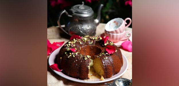 rose cardamom cake recipe pistachio cake with rose water winter cake recipe eggless rose cake cardamom pistachio dessert saffron cake Indian fusion cake aromatic cake recipe moist rose cake easy winter dessert floral flavored cake festive Indian cake white chocolate glaze cake how to make rose cake step by step rose cake ingredients rose and cardamom dessert rose cake with yogurt saffron infused cake unique cake recipe