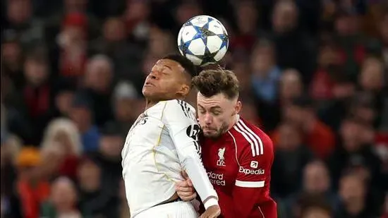 Liverpool Real Madrid Champions League Conor Bradley Vinicius Junior Arne Slot Trent Alexander Arnold Kylian Mbappe Jurgen Klopp Anfield Alexis Mac Allister Dominik Szoboszlai Thibaut Courtois Premier League Manchester City Etihad Stadium European football match report football highlights defensive performance Liverpool vs Real Madrid Bradley performance Slot tactics clean sheet football news Mbappe Real Madrid defeat